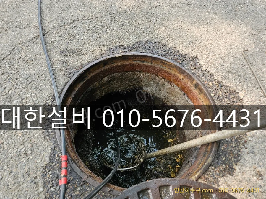맨홀을 열고 고압세척으로 배관 내 기름때를 밀어내는 작업