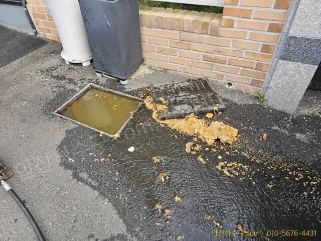 반월공단 공장 폐수 역류 현장에서 맨홀을 열고 고압세척을 준비하는 안산하수구 작업 모습