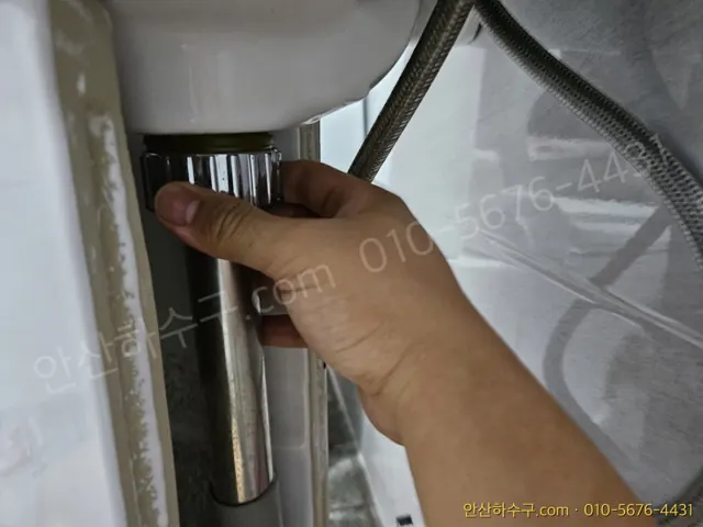 세면대 아래 앵글밸브에 급수호스를 손으로 연결하는 장면