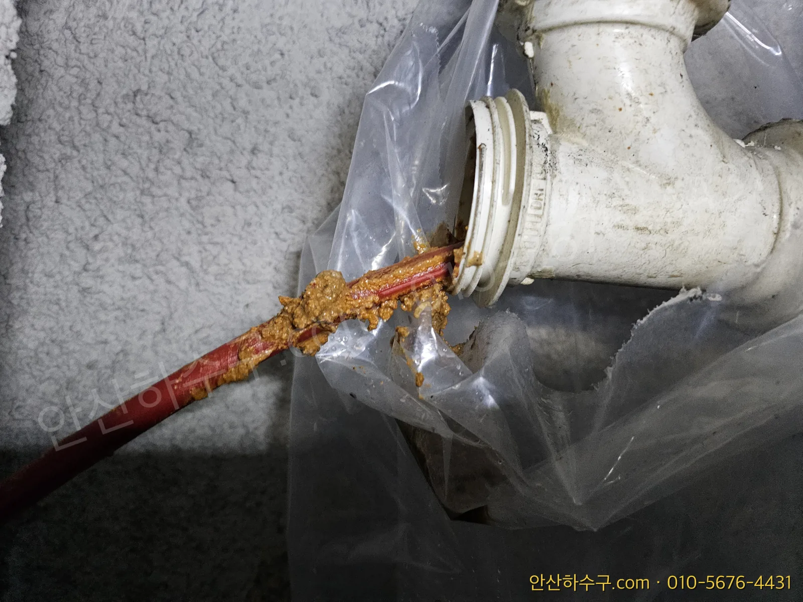 지하 배관에 고압세척 호스를 넣어 기름 덩어리를 씻어내는 작업