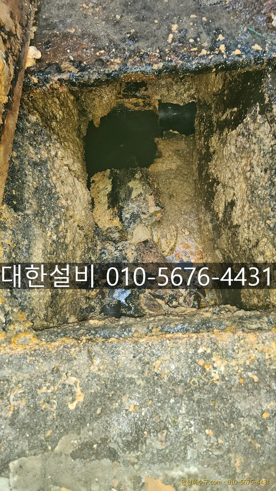 안산 초지동 식당 하수구 역류 현장에서 기름때로 가득 찬 맨홀을 확인하는 안산하수구 작업 모습
