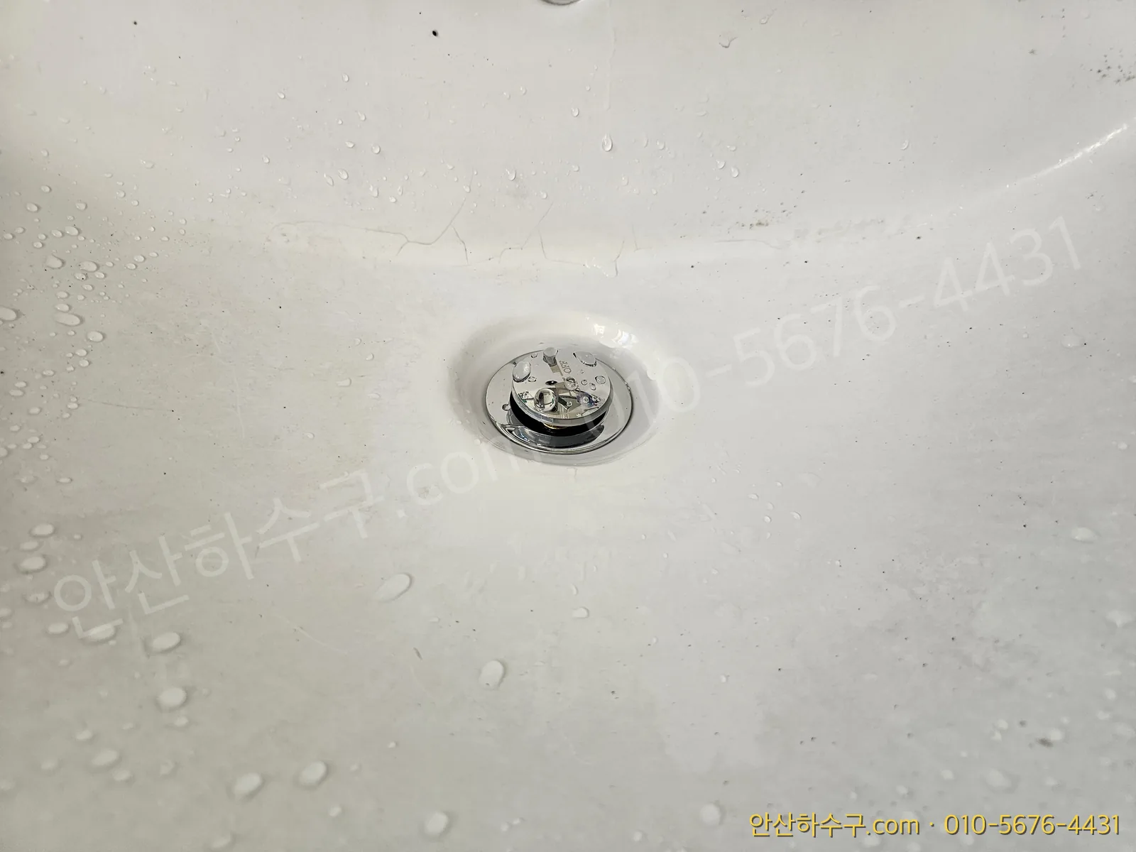 새로 교체한 폽업에 물을 흘려 배수를 확인하는 모습