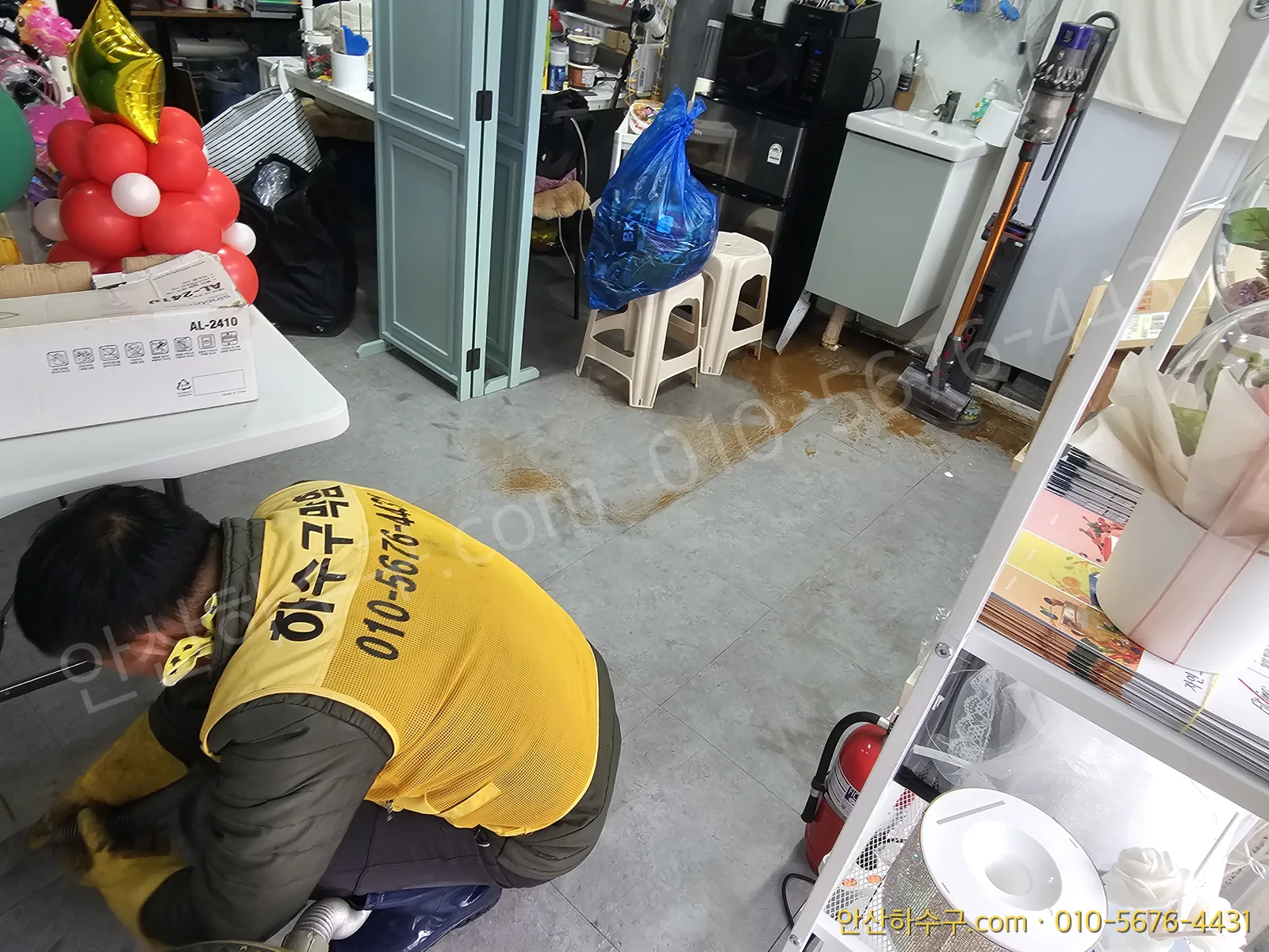 안산 사동 아파트상가 하수구역류 현장에서 바닥에 깔린 침전물과 배관 상태를 살피는 안산하수구 작업 모습