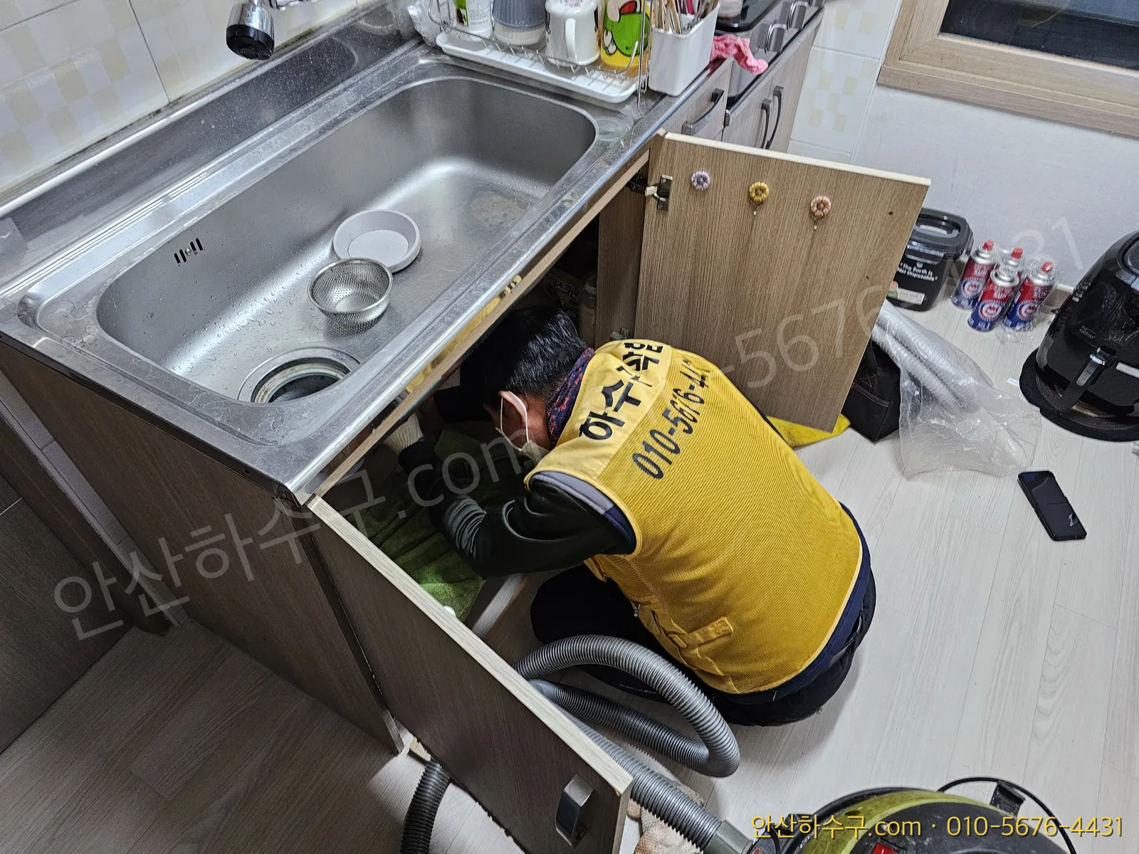 석션으로 싱크대 배관 속 고인 물과 이물질을 빨아내는 작업