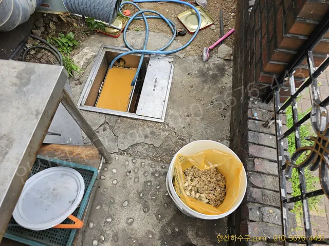 안산 신길동 공장 구내식당 트렌치를 열고 걷어 낸 음식물처리기 분쇄물을 확인하는 안산하수구 작업 모습