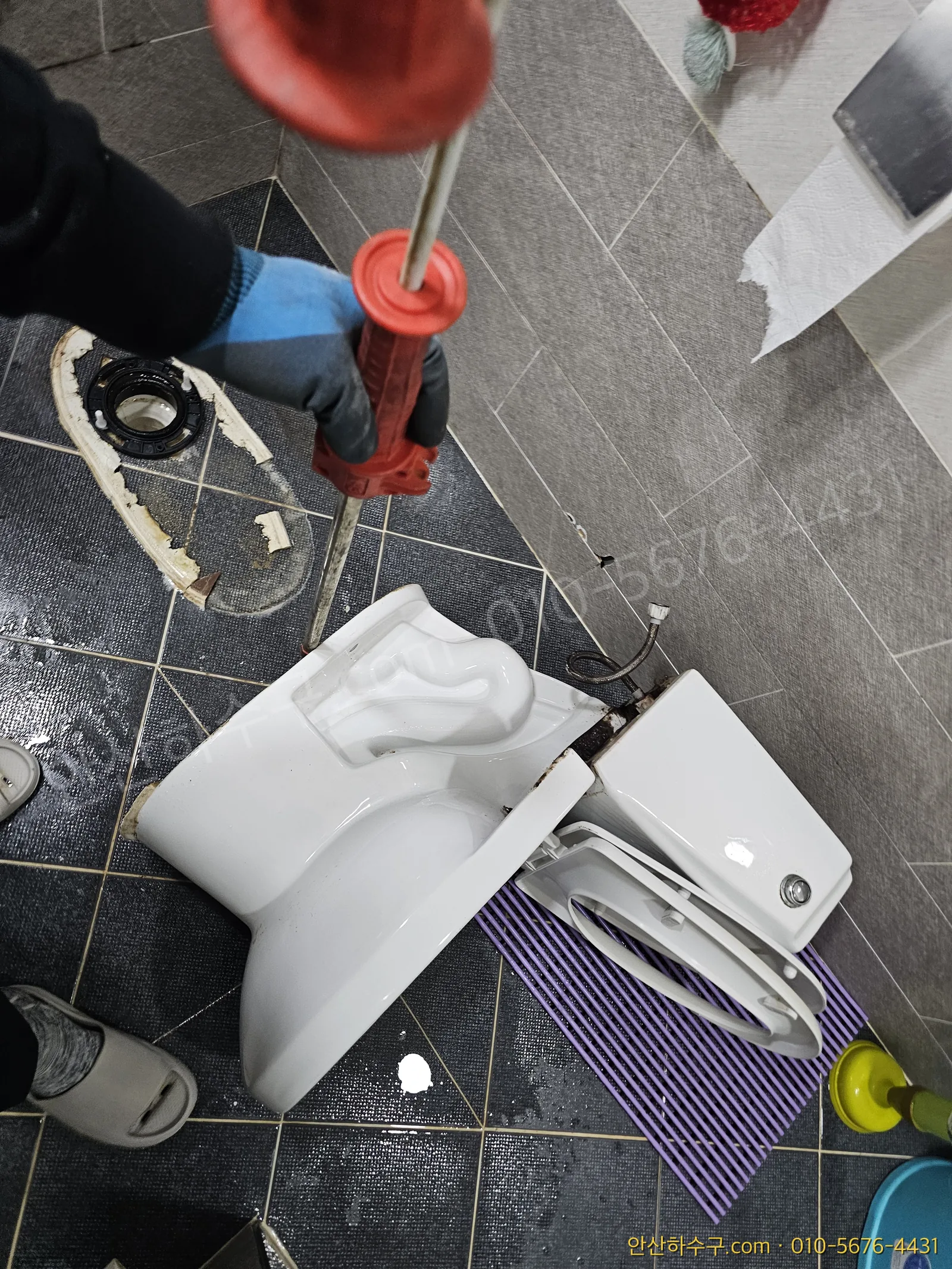 집게로 변기 초입의 이물질을 꺼내려 시도하는 작업