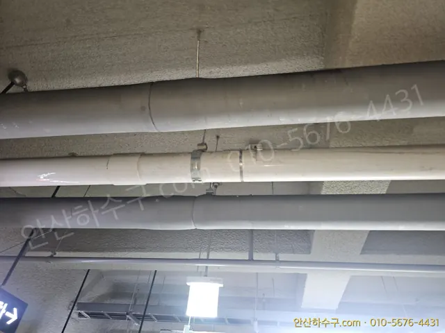지하 천장을 지나가는 아파트 횡주관과 입상관 연결부 — 건물 단위 세척 구간 확인