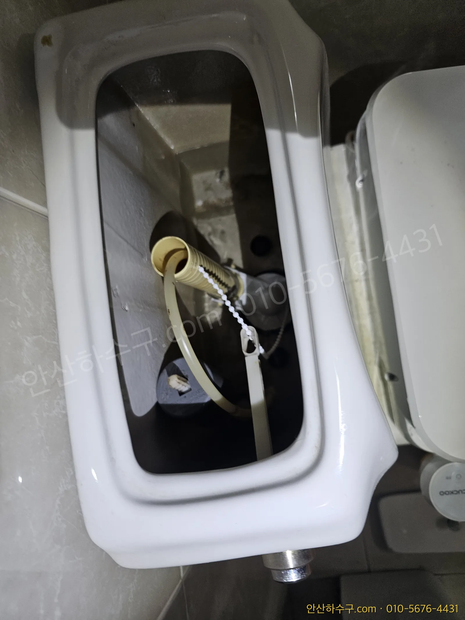 안산 변기 물탱크 뚜껑을 열어 필밸브와 플러시밸브가 보이는 내부 — 변기 물이 안 차거나 계속 흐를 때 갈아 끼우는 부속