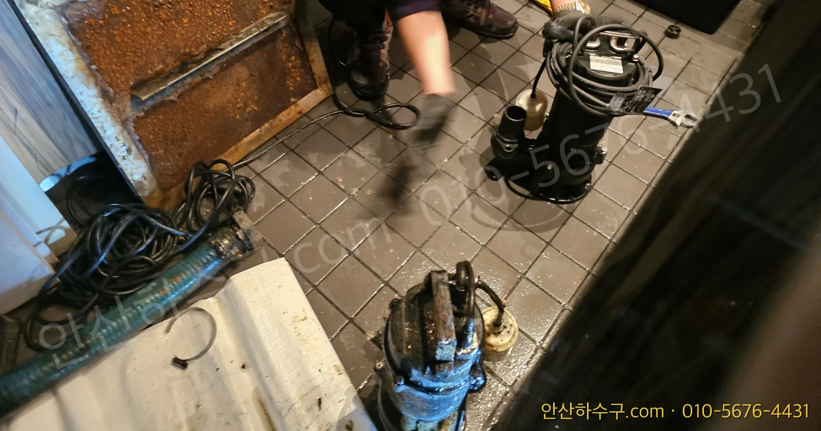 교체를 위해 집수정에서 꺼낸 수중펌프 본체와 케이블 — 명판은 본체 옆면에 붙어 있습니다